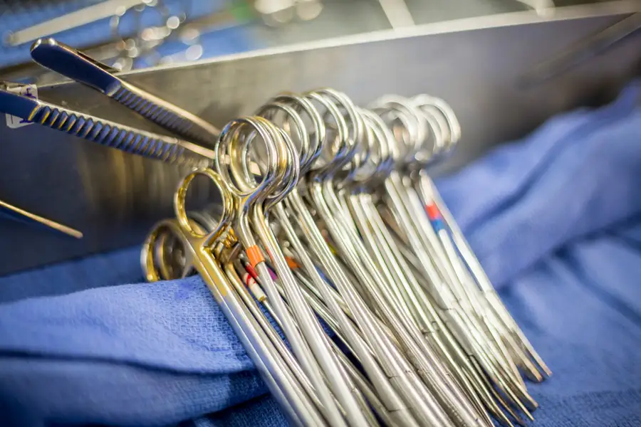 A row of hemostats on surgical gauze in an operating room